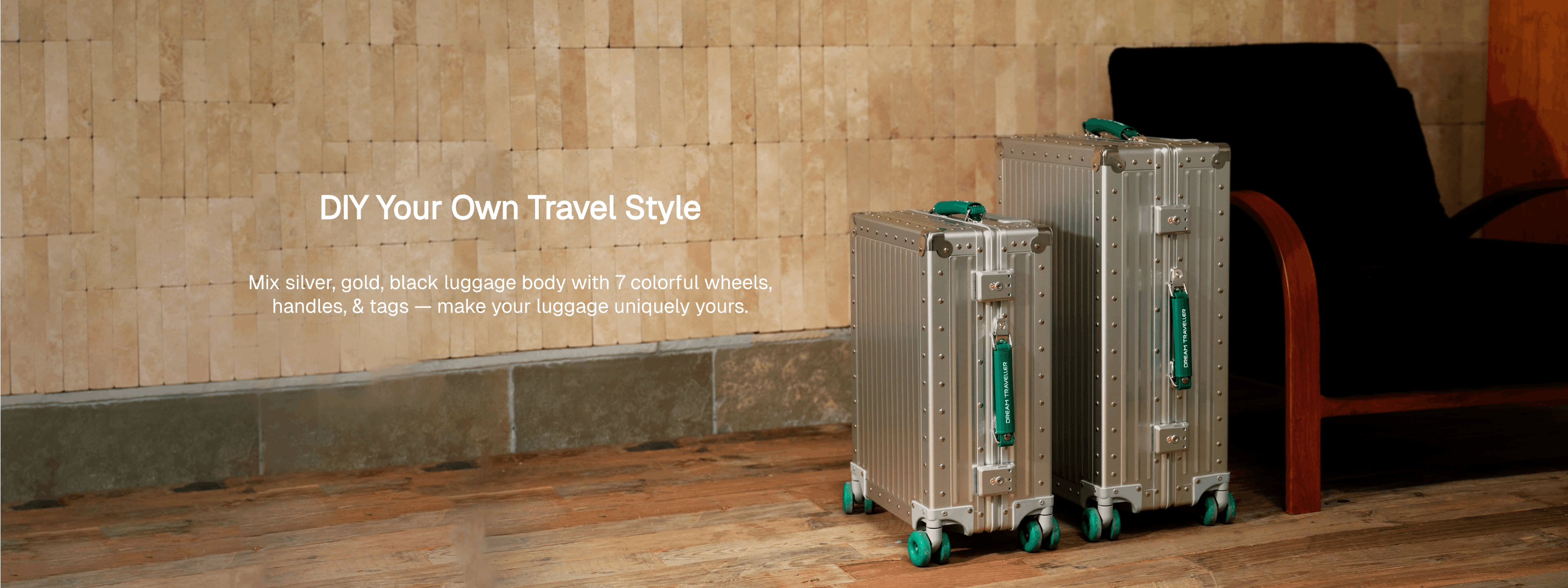 Two silver suitcases with green wheels on a wooden floor against a stone wall.
